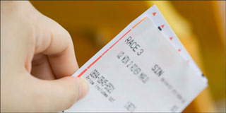 hand holding a racing ticket with a yellow background